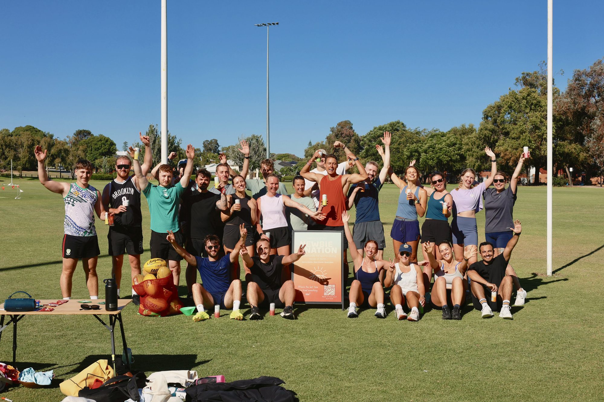 A big group of Newbie Nation newbies cheering on an oval after an AFL intro social in Perth