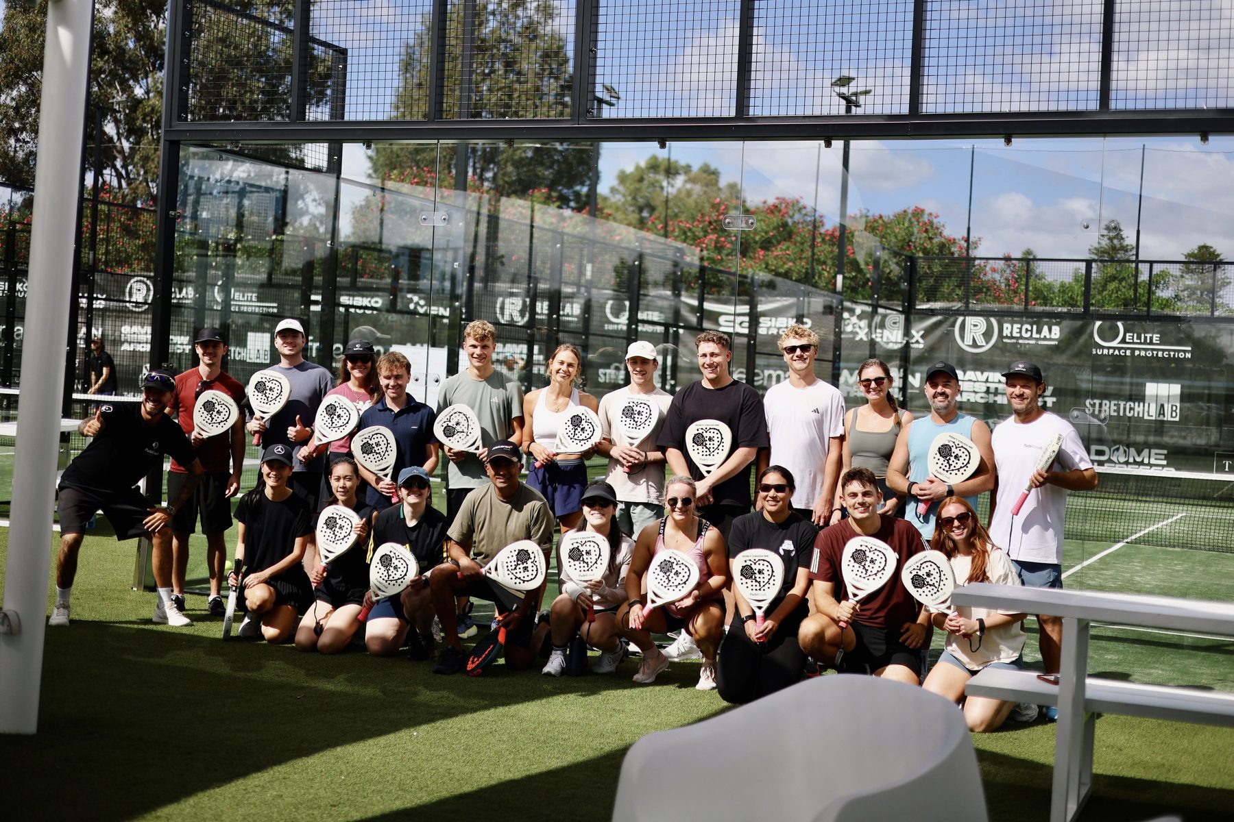 Padel social group photo with paddles at Padel Crush Wembley