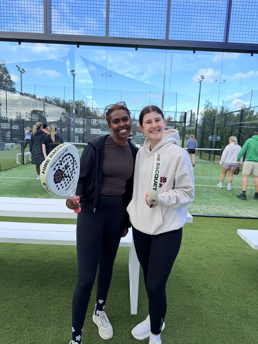 Two newbies with padel paddles
