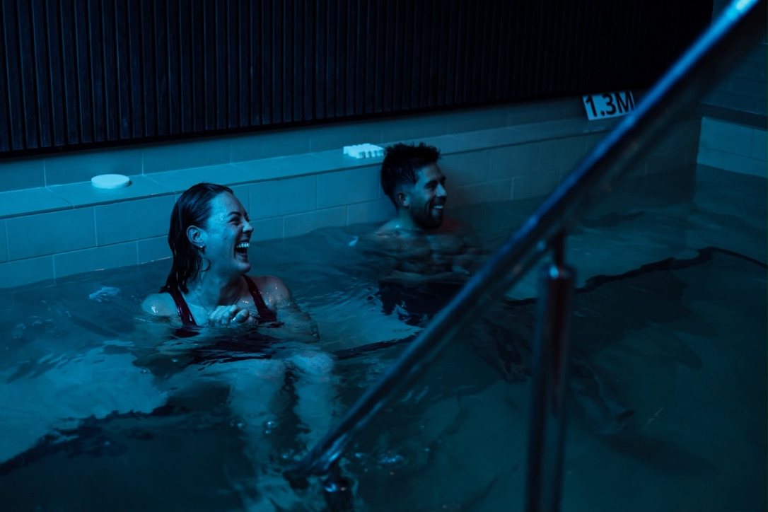 Two newbies laughing in the recovery pool after a hybrid social