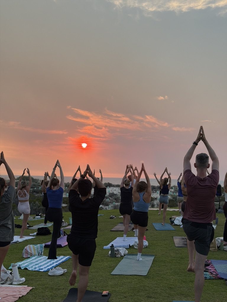 Sunset yoga in tree pose overlooking the ocean
