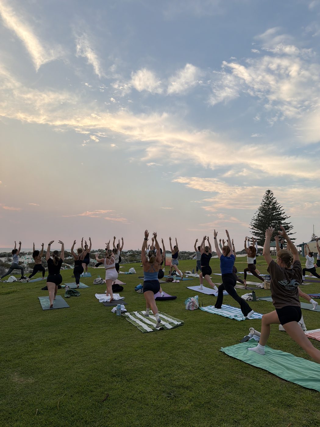 Sunset yoga on the grass by the beach